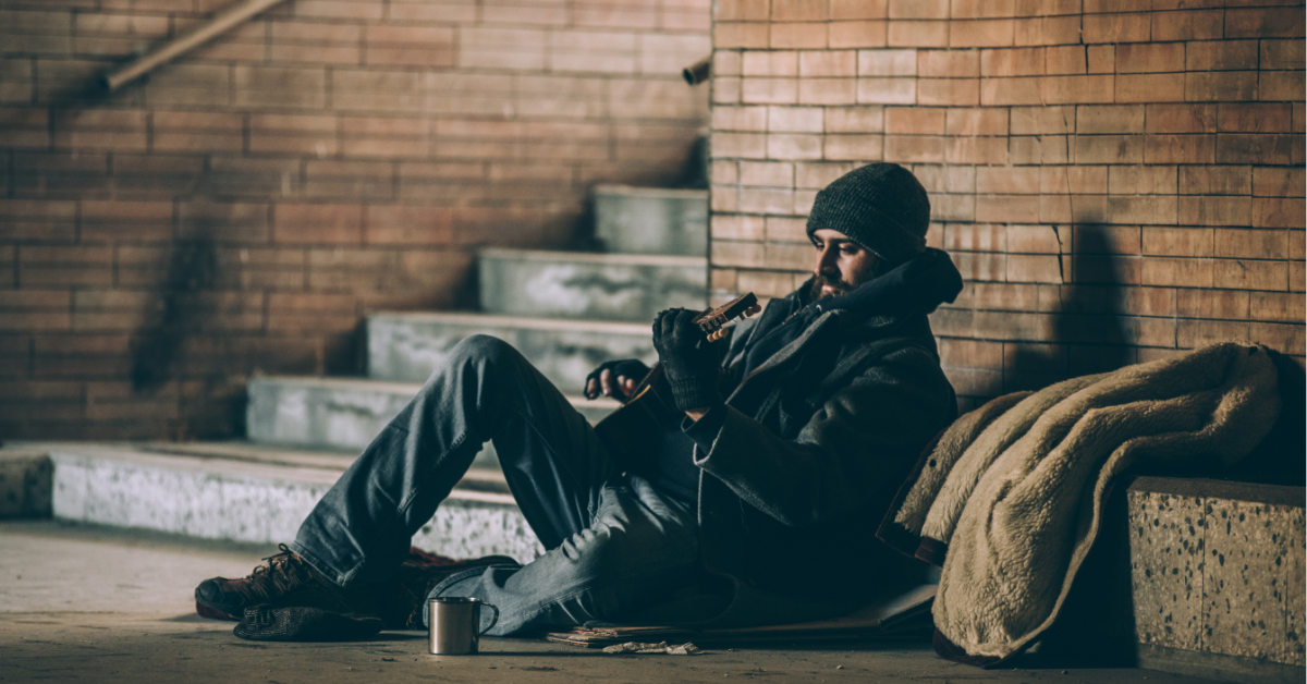 Man sitting outside playing guitar