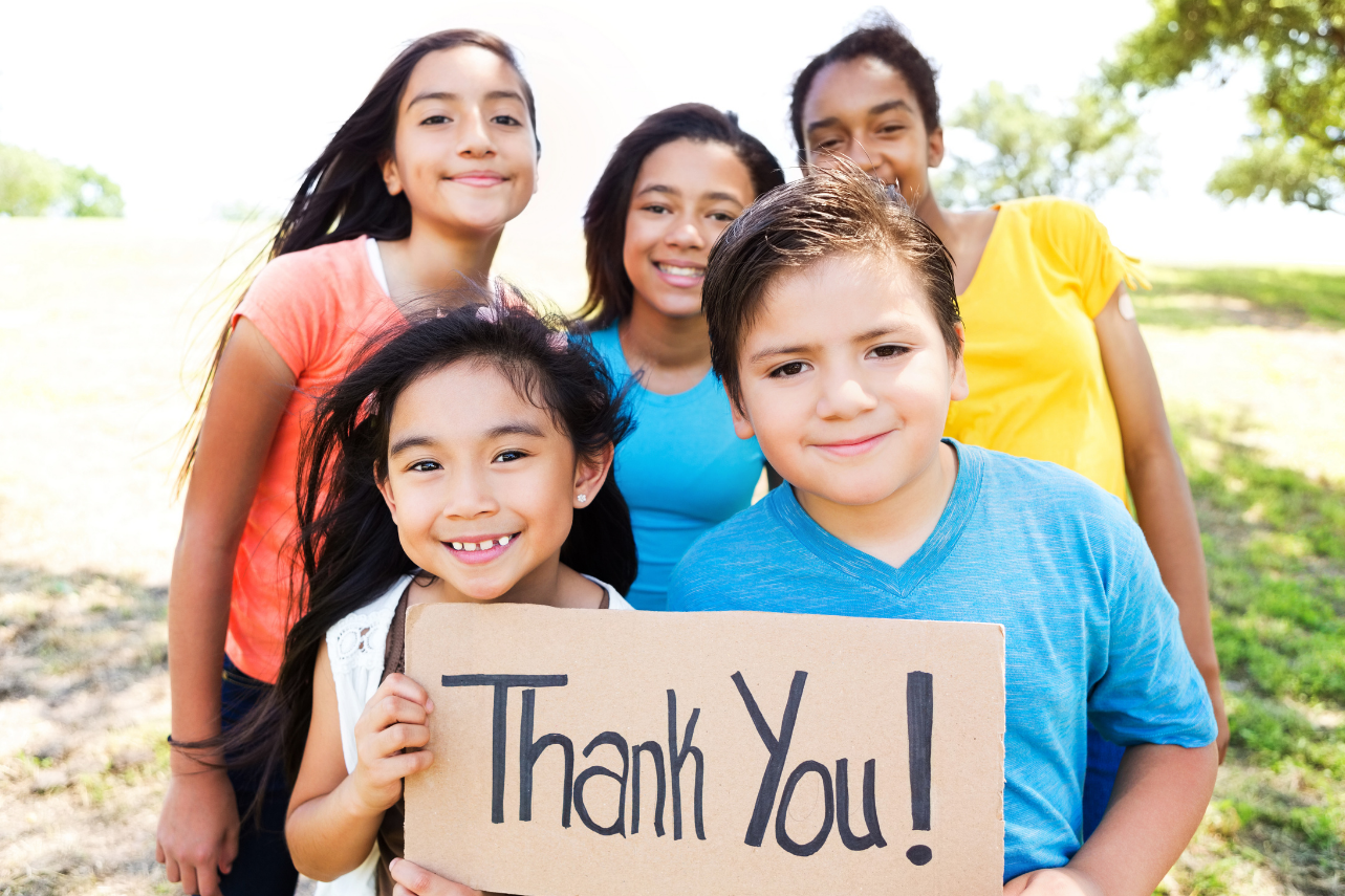 Group of children holding "thank you" sign