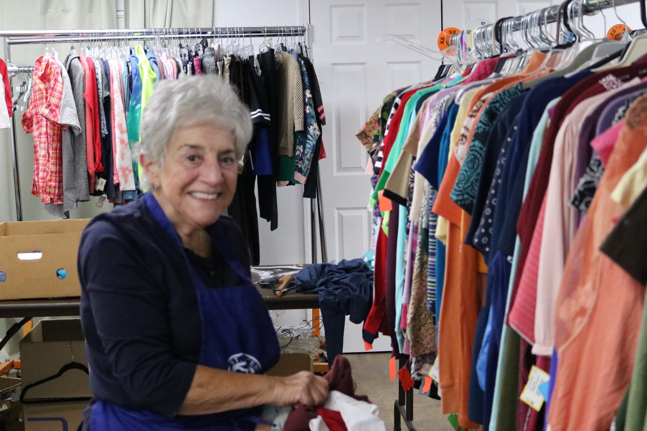 Old woman smiling while volunteering in SVDP thrift store