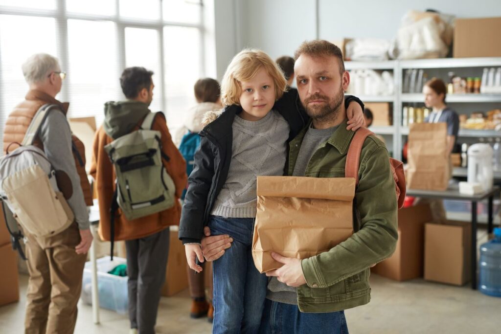 Man holding bag of food and son