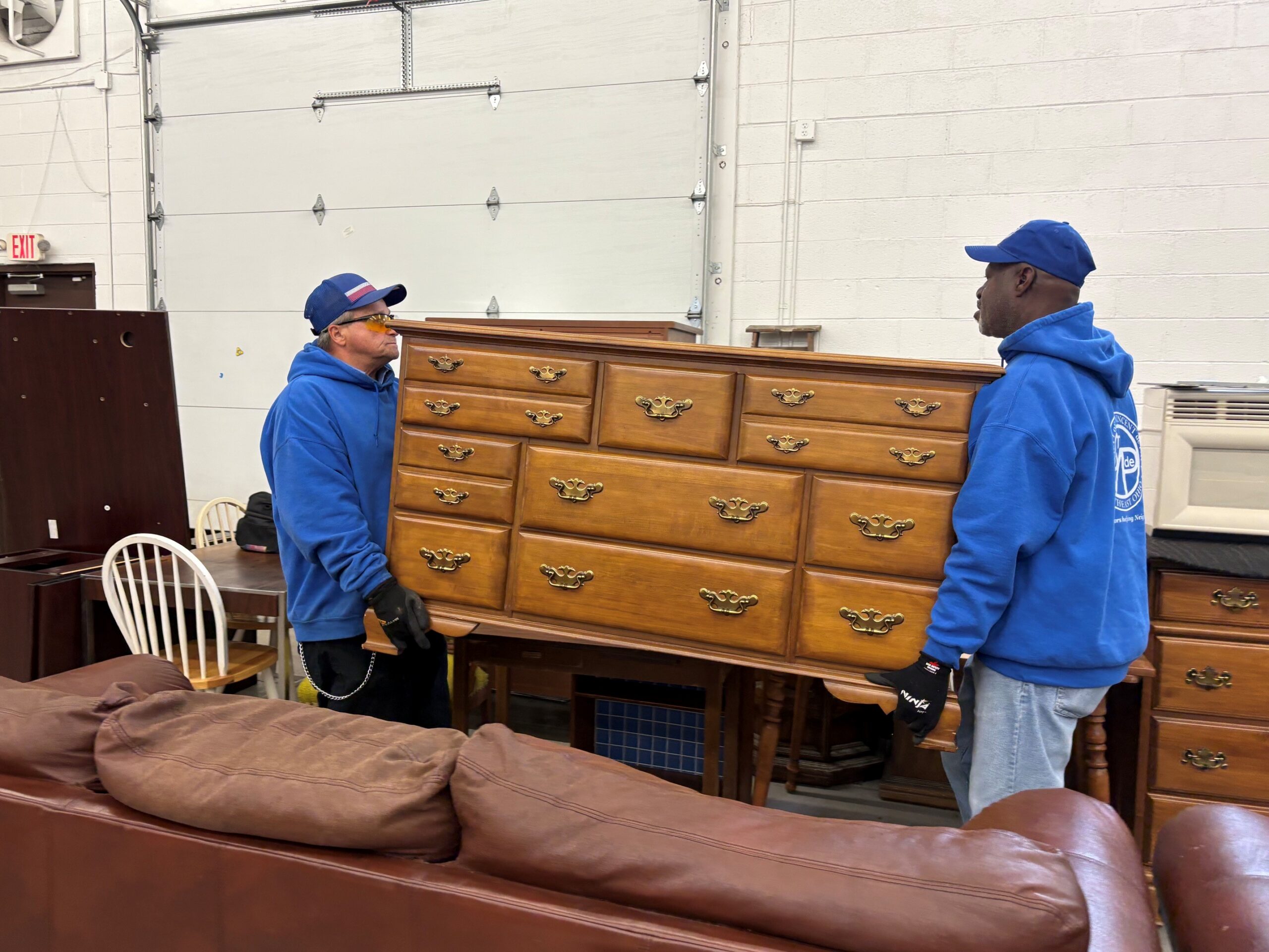 2 volunteers moving dresser