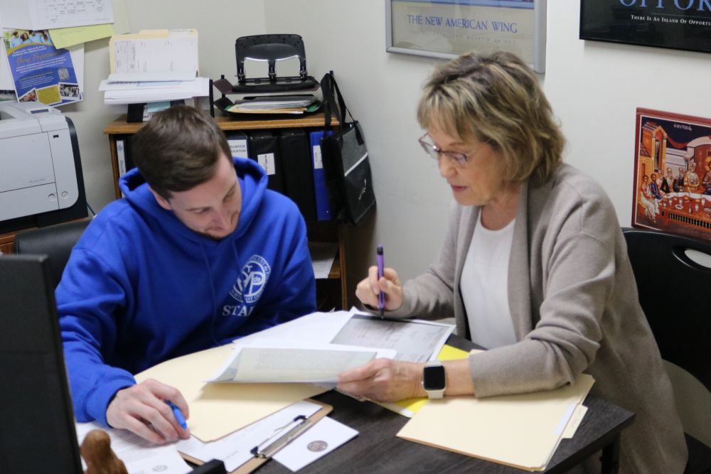 Volunteer officer helping someone fill out paperwork
