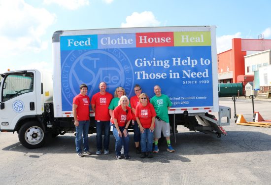 SVDP members smiling in front of SVDP truck